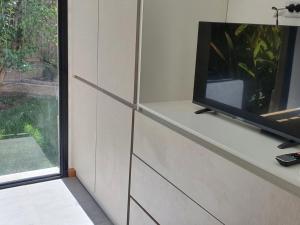 TV sentada en un estante en una habitación con ventana en The owl lodge en Luján de Cuyo