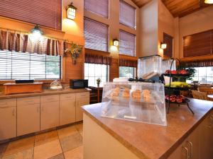 a kitchen with a counter with a container of donuts at Kelly Inn and Suites Mitchell in Mitchell