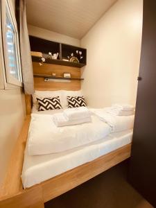een kleine slaapkamer met een bed met witte lakens bij MAGNOLIA HOUSE by the RIVER in Metlika