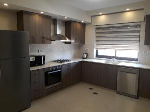 uma cozinha com armários de madeira e um frigorífico em Bethlehem apartments that offer comfort and value. em Belém