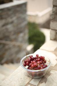 a bowl of grapes sitting on a table at Aithra -Agios Petros Andros in Gavrio