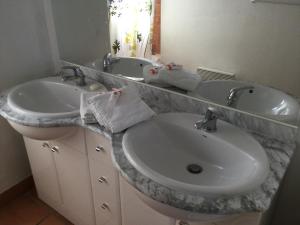 uma casa de banho com 2 lavatórios e um balcão de mármore em Chez Tranquille, Apartment 43 em Montblanc