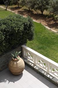 a large vase sitting next to a white bench at Aithra -Agios Petros Andros in Gavrio