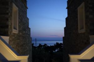 a view of the ocean from between two buildings at Aithra -Agios Petros Andros in Gavrio