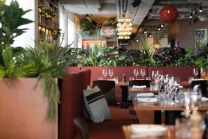 um restaurante com mesas, cadeiras e plantas em YUST Liege em Liège