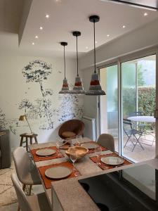 une salle à manger avec une table, des assiettes et des verres dans l'établissement Superbe appartement avec jardin Saint Charles, à Biarritz
