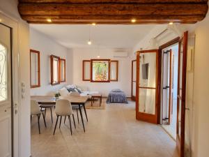 ein Esszimmer und ein Wohnzimmer mit einem Tisch und Stühlen in der Unterkunft Yvi´s Greek House in Vaia