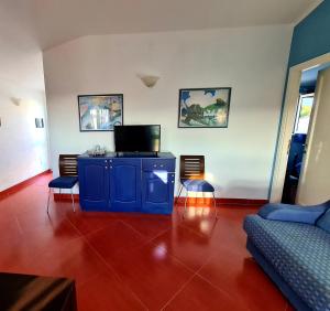 sala de estar con armario azul y sofá en Casa Luna, en Lu Pultiddolu