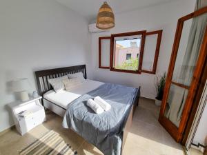 1 dormitorio con cama con espejo y ventana en Yvi´s Greek House en Vaia