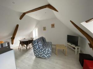 ein Wohnzimmer mit einem Stuhl und einem Tisch in der Unterkunft Appartement confortable proche des Thermes avec lave-vaisselle et options de location de linge - FR-1-541-9 in La Roche-Posay