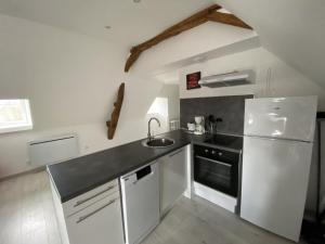 eine Küche mit einem weißen Kühlschrank und einer Spüle in der Unterkunft Appartement confortable proche des Thermes avec lave-vaisselle et options de location de linge - FR-1-541-9 in La Roche-Posay + 2 Fotos