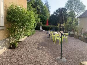eine Terrasse mit Stühlen und einem Sonnenschirm auf einer Stange in der Unterkunft Appartement confortable proche des Thermes avec lave-vaisselle et options de location de linge - FR-1-541-9 in La Roche-Posay