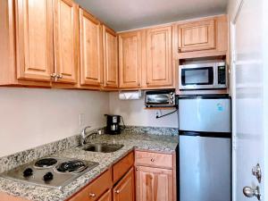 a small kitchen with wooden cabinets and a refrigerator at Copley House Extended Stay in Boston