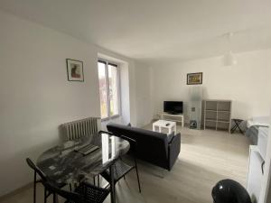 ein Wohnzimmer mit Tisch und Couch in der Unterkunft Appartement Rénové avec Cuisine Américaine et WIFI, Proche des Thermes Saint Roch - FR-1-541-32 in La Roche-Posay