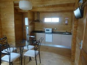 a dining room with a table and chairs and a kitchen at Monte do Azibo Glamping in Podence