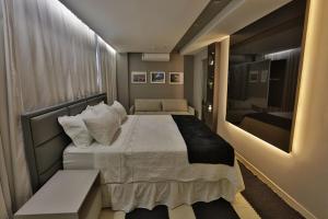 a bedroom with a large bed and a mirror at Uchôa Teresina Hotel in Teresina