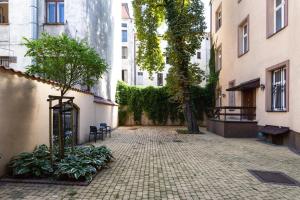 une cour vide avec des arbres, des plantes et des bâtiments dans l'établissement Aparts by Hostly, à Cracovie