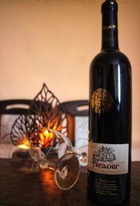 una bottiglia di vino seduta su un tavolo con una candela di Apartman Anja a Trebinje