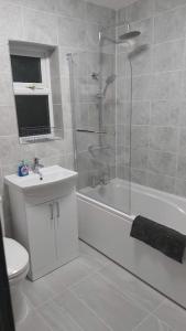 a bathroom with a shower and a toilet and a sink at White Shelf Dartford House in Kent