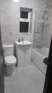 a bathroom with a toilet and a sink and a shower at White Shelf Dartford House in Kent