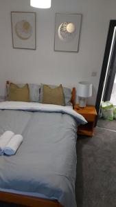 a bedroom with a large bed with two pillows at White Shelf Dartford House in Kent