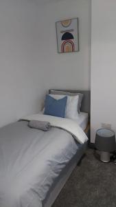 a white bed with blue pillows in a room at White Shelf Dartford House in Kent