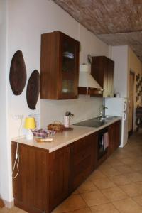 eine Küche mit Holzschränken, einer Spüle und einem Kühlschrank in der Unterkunft L'Angoletto in Trecastagni