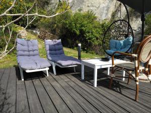3 Stühle und ein Tisch auf einer Terrasse in der Unterkunft OASIS in Menton