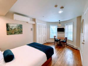 a bedroom with a bed and a table in it at Copley House Extended Stay in Boston