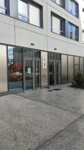 budynek ze szklanymi drzwiami i znakiem na nim w obiekcie °Le métropole° Check in H24/wifi w mieście Lyon