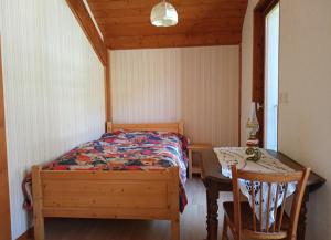 a bedroom with a bed and a desk and a table at Chez Mémé Cour in Bellevaux