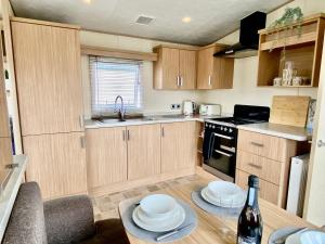 una cocina con armarios de madera y una mesa con platos. en The Windermere, en Whitstable