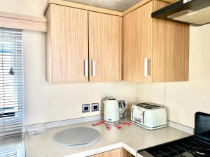 a kitchen with wooden cabinets and a toaster and a toaster at The Windermere in Whitstable