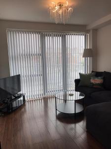 a living room with a couch and a coffee table in front of windows at VICTORIA PLACE in Belfast
