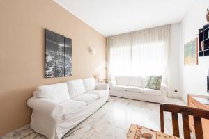 una sala de estar con 2 sofás blancos y una ventana en Vatican De Carolis Terrace, en Roma