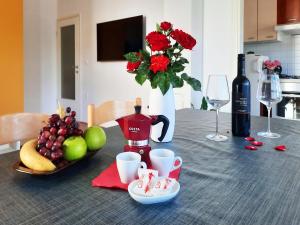 a table with a bottle of wine and some fruit at Apartment Violetta-Punta in Umag