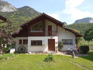 a house with mountains in the background at Chez Mémé Cour in Bellevaux