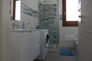 a bathroom with a washing machine and a sink at Akoya Apartments in San Vito lo Capo