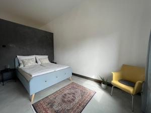 a bedroom with a bed and a chair and a rug at Holidayloft & Office in der alten Margarinefabrik in Bredstedt