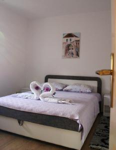 una camera da letto con un letto e asciugamani a forma di cigno di Apartman Anja a Trebinje