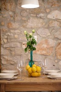 a table with a vase with a flower and lemons on it at Apartment House Bucul in Mali Lošinj