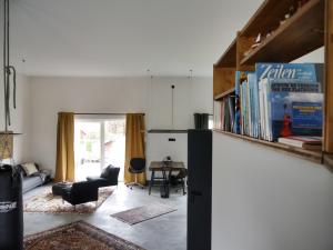a living room with a book shelf and a table at Holidayloft & Office in der alten Margarinefabrik in Bredstedt