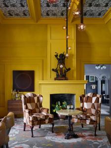 希爾茲堡的住宿－The Madrona，客厅配有两把椅子和壁炉