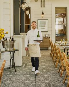 a man holding a tray with a bottle of wine at The Madrona in Healdsburg +21 photos