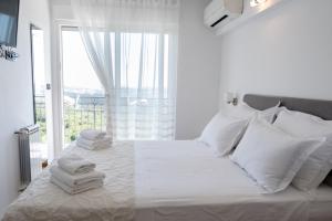 a white bedroom with a bed with towels on it at Villa Diosa de la Aurora in Klis +44 photos