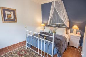 een slaapkamer met een groot bed met een baldakijn bij Harmonie Farm Cottages in Montagu