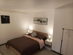 a bedroom with a bed and two night stands with lights at Le pain perdu de germaine in Château-Gontier