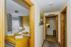 a bedroom with a bed with a yellow bedspread at 2 Bedroom Garden Apartment Near QMC, Tennis Centre & City in Nottingham