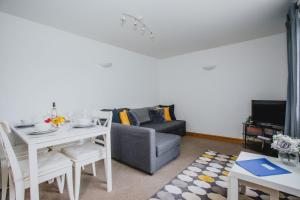 a living room with a table and a couch at 2 Bedroom Garden Apartment Near QMC, Tennis Centre & City in Nottingham