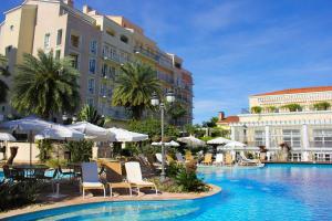 una piscina en un hotel con sillas y sombrillas en Cobertura com cozinha dentro de resort - Direto com proprietário ILCTOPM en Florianópolis